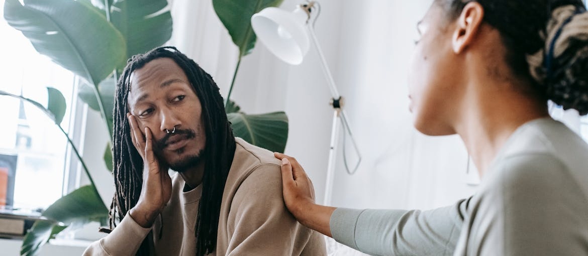 Woman comforting a man in therapy.