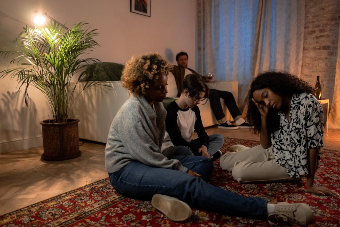 Father drinking alcohol while his children experience the bad impact of parental addiction on child development.