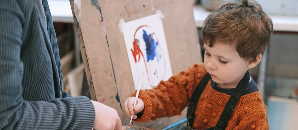 People in art class helping a child whose parent is struggling with addiction.