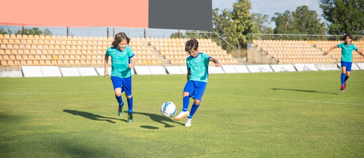 Young boys playing soccer in a field.