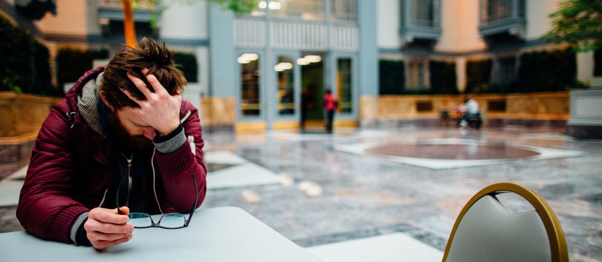 Man sitting at a table and worrying can meth cause mental illness.