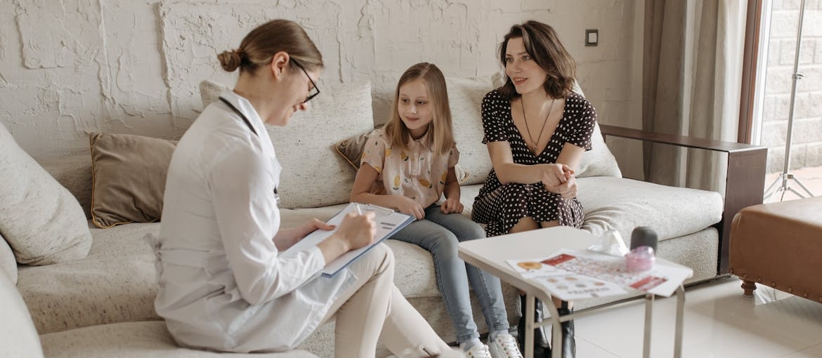 Young girl and her mother talking with a therapist.