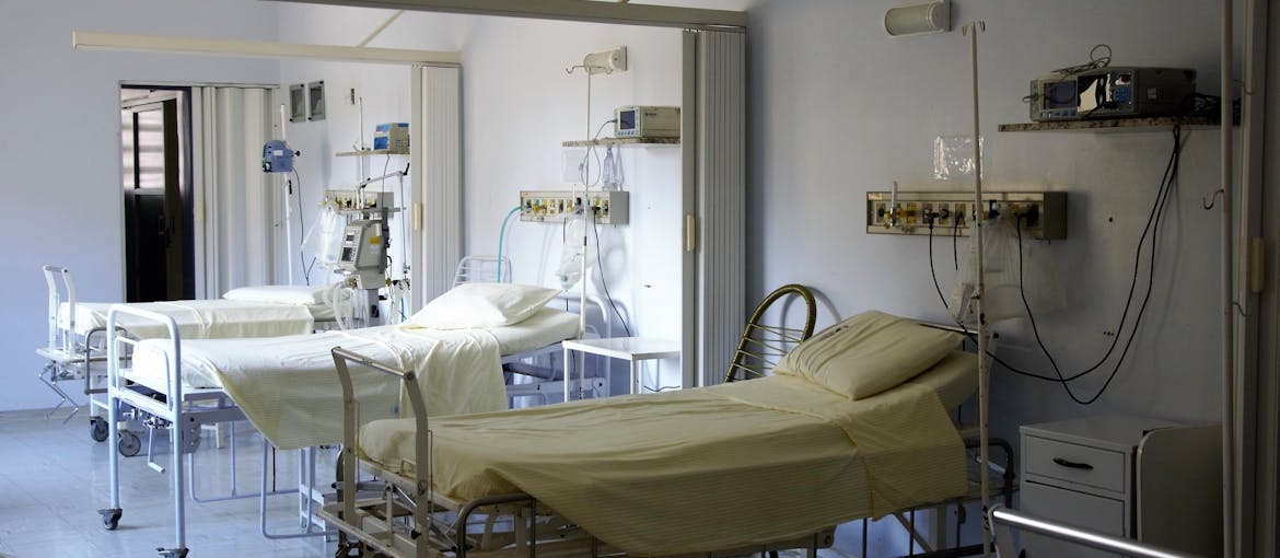 Inside of a hospital room with empty beds.