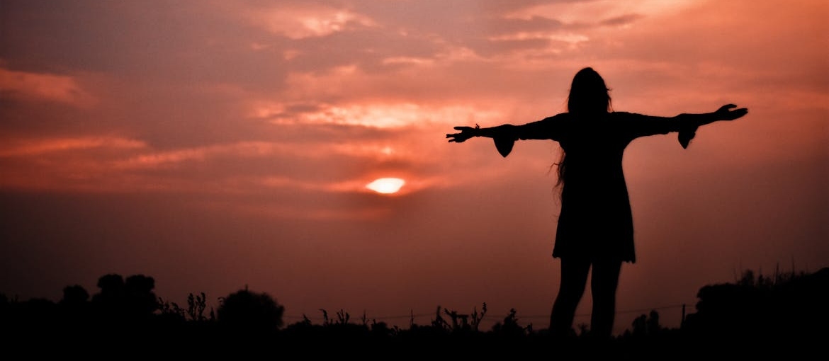 Woman lifting her hands towards the sky while practicing gratitude exercises.
