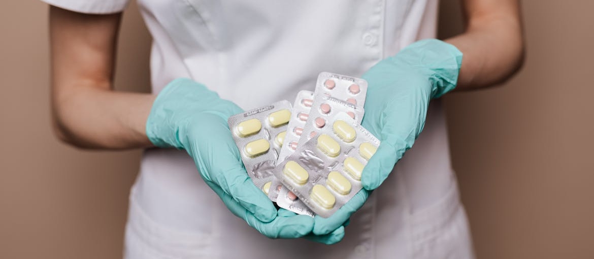 Pharmacist holding blisters of pills.