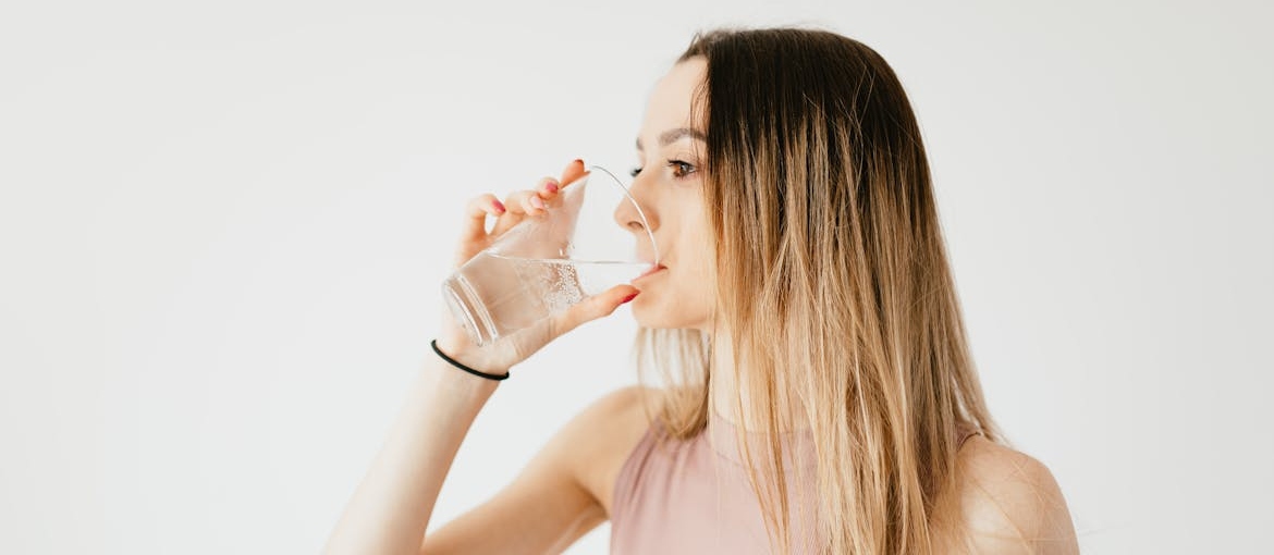 Woman drinking water in order to wean off Prozac.