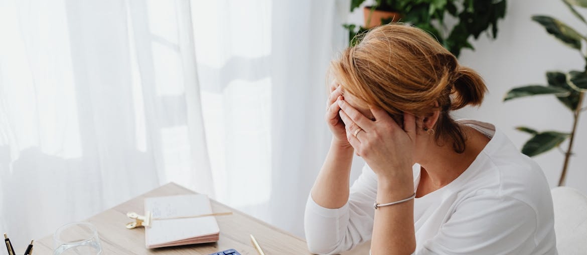 Woman having a headache while experiencing Lexapro withdrawal symptoms.