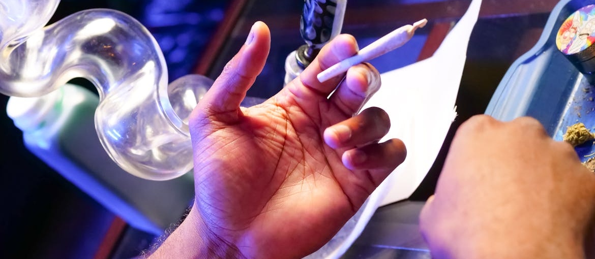 Person holding a marijuana blunt.