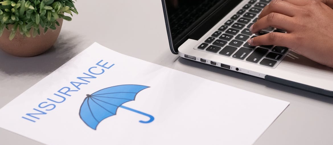 Insurance papers next to a laptop.