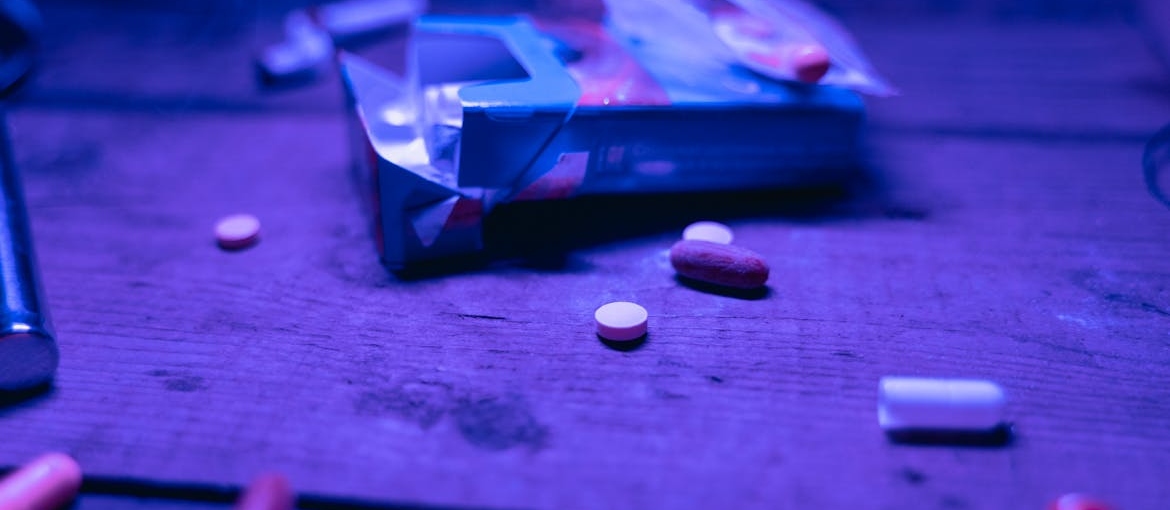 Ecstasy pills next to an open box of cigarettes.