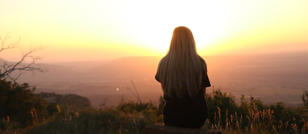 Woman sitting on the grass in isolation.