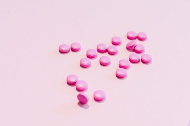 Pink pills on a pink background.