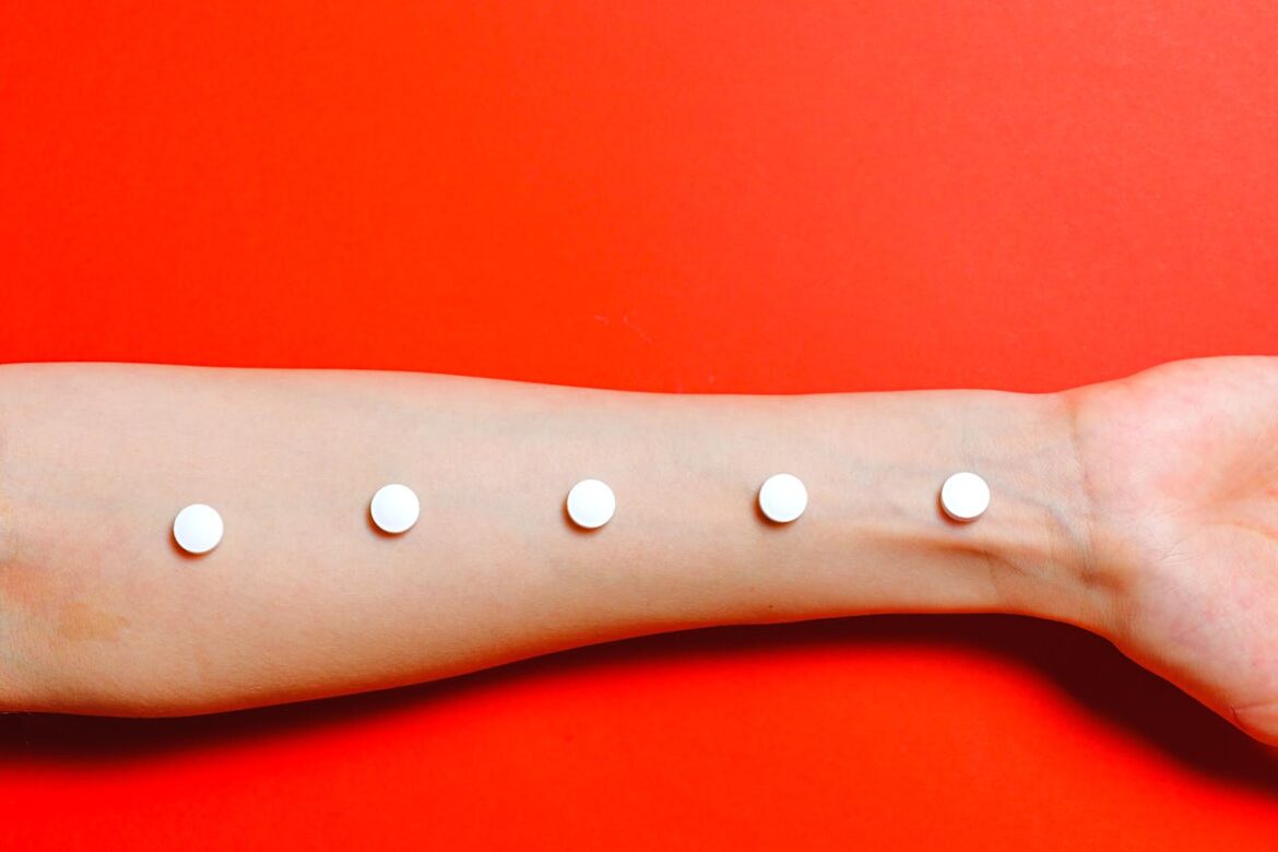 White pills on a person's hand.