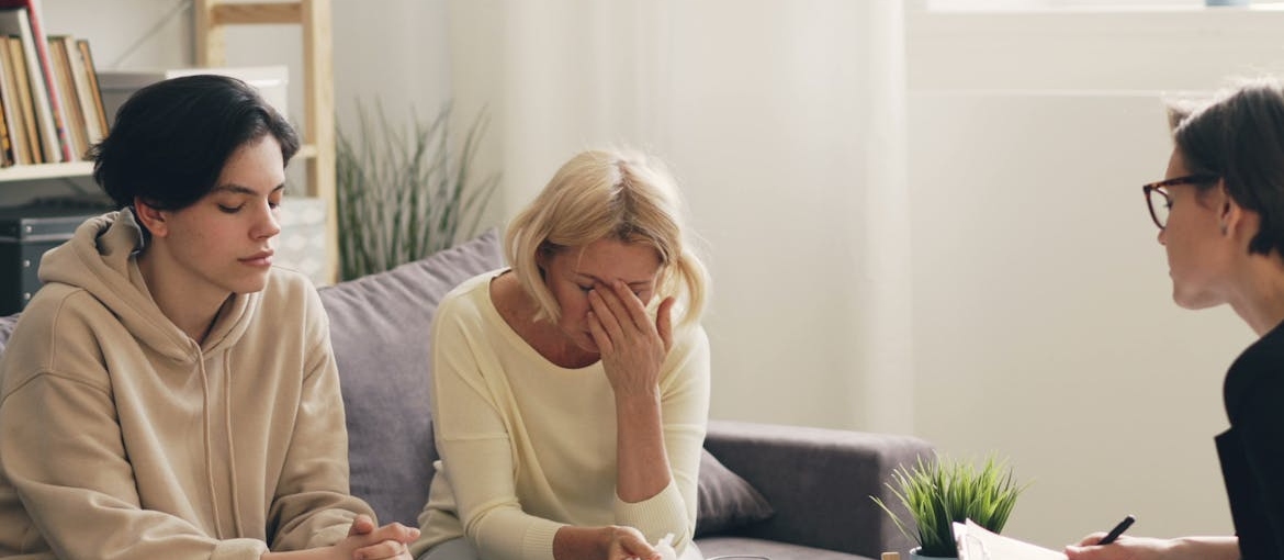 Mother and her child talking with a therapist while choosing OTP program.