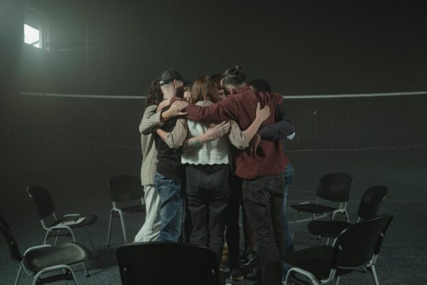 People in mental health support groups hugging in a circle.