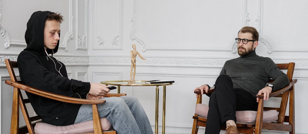 Young man talking about his struggles with transfer addiction with his therapist.