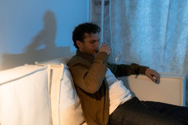 Man drinking wine while struggling with PTSD and alcohol use.