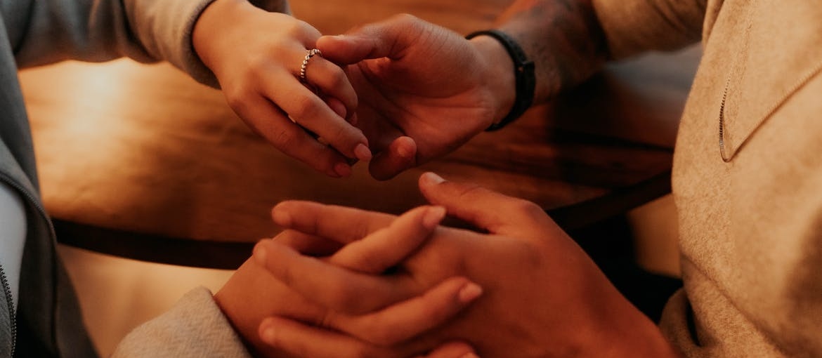 Couple sitting at a table and holding hands.
