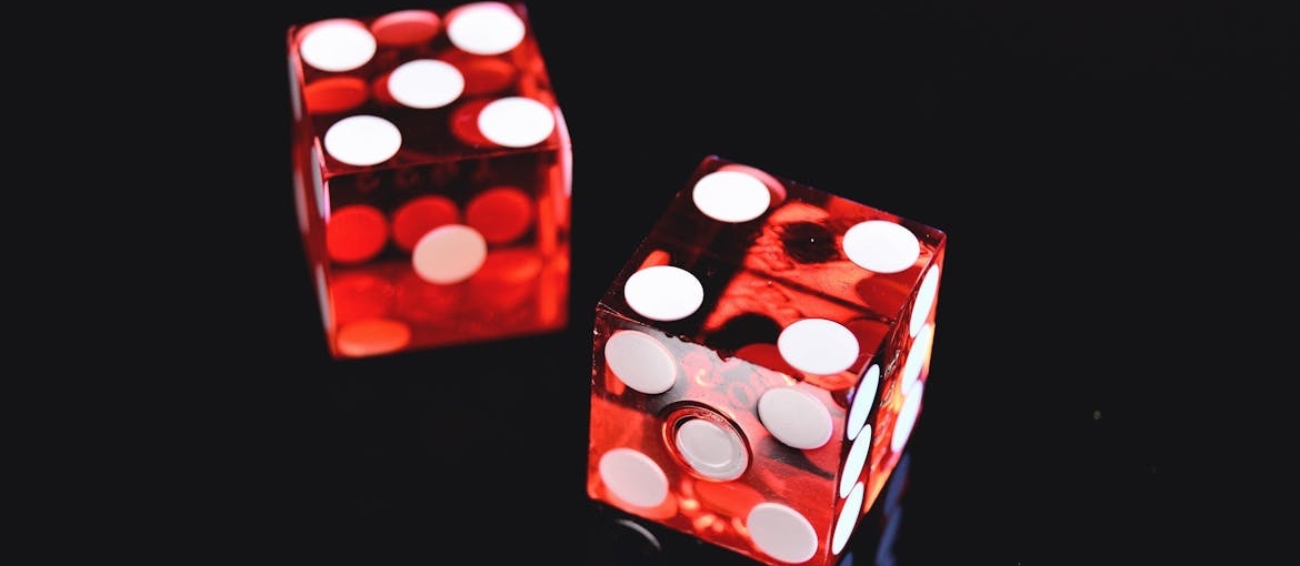 Two red dice on a black background.