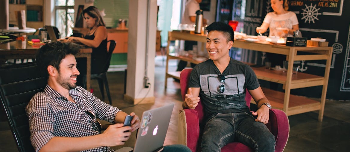 Two men having a conversation in a cafe.