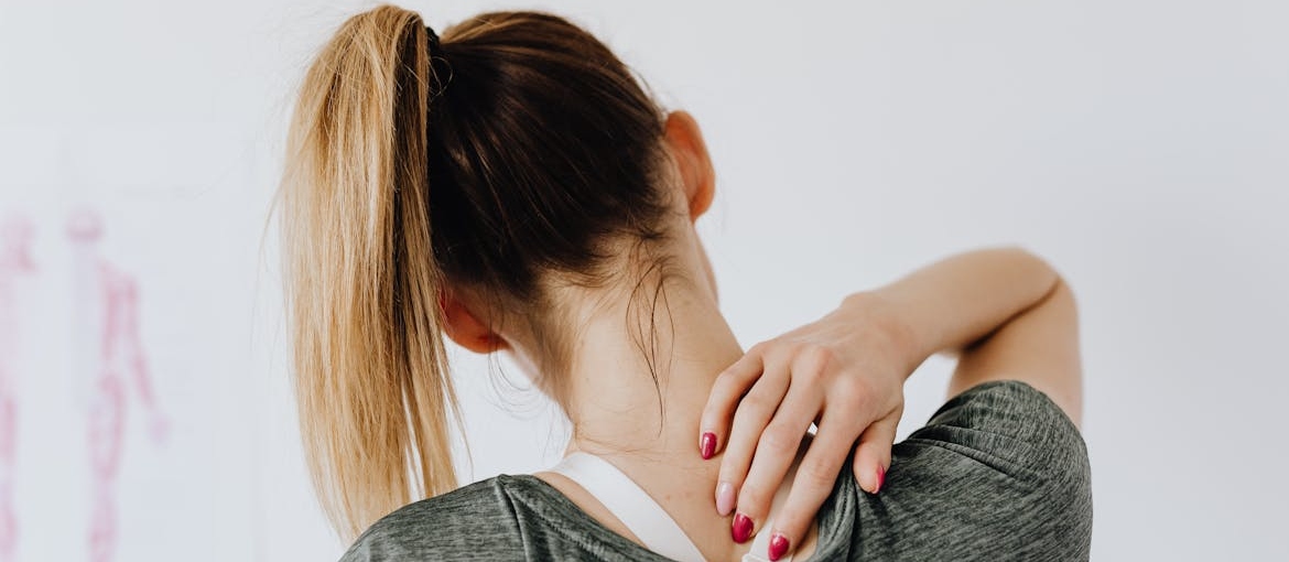 Woman touching the back of her neck and back.