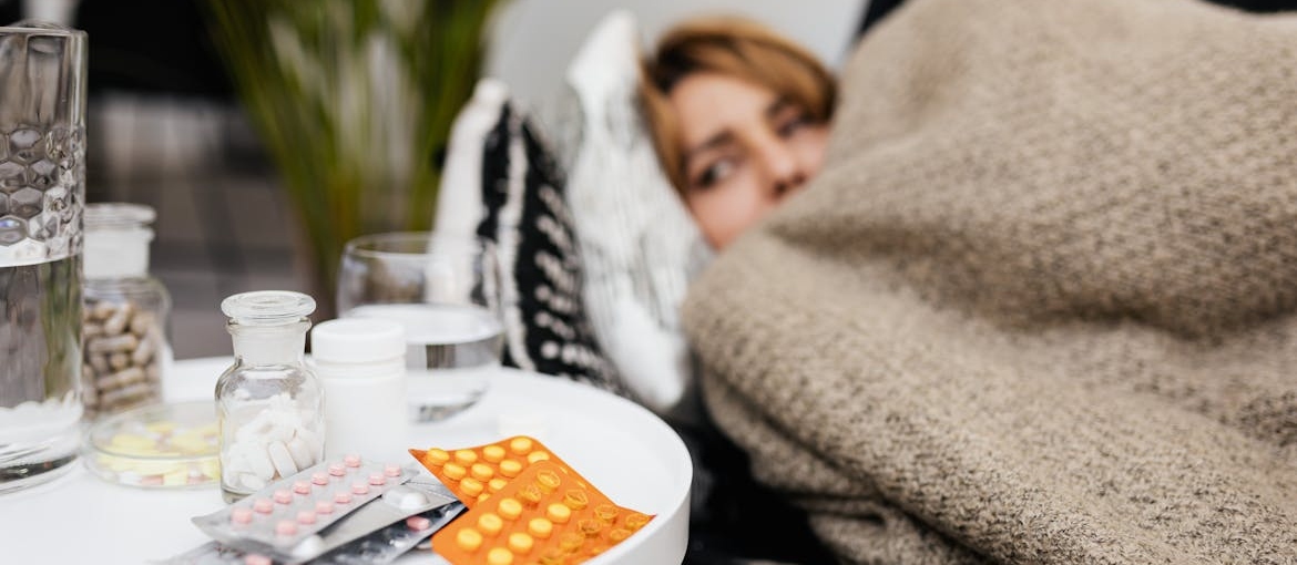 Woman lying on the couch while looking at the delirium tremens medication on her nightstand.