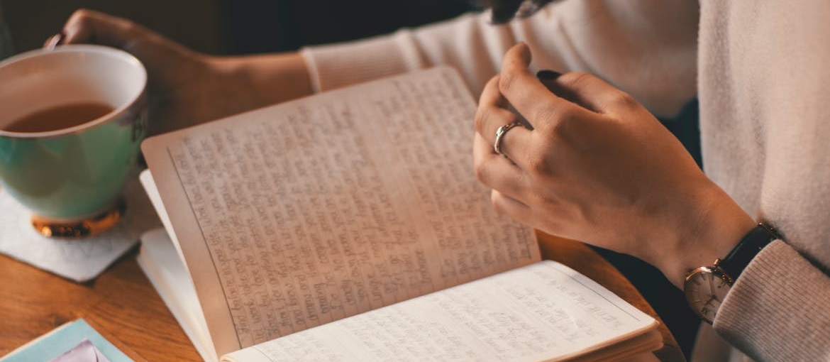 Woman drinking tea and journaling her worries about can you have withdrawals from weed.