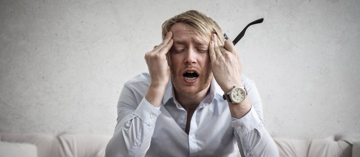 Frustrated man sitting on the couch and worrying about can you have withdrawals from weed.
