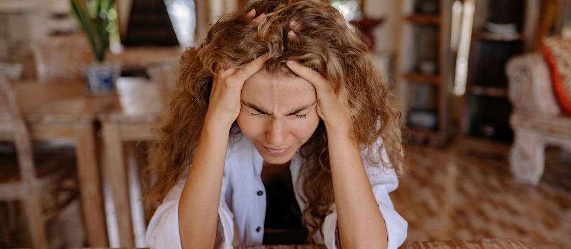 Stressed out woman holding her head in her hands.
