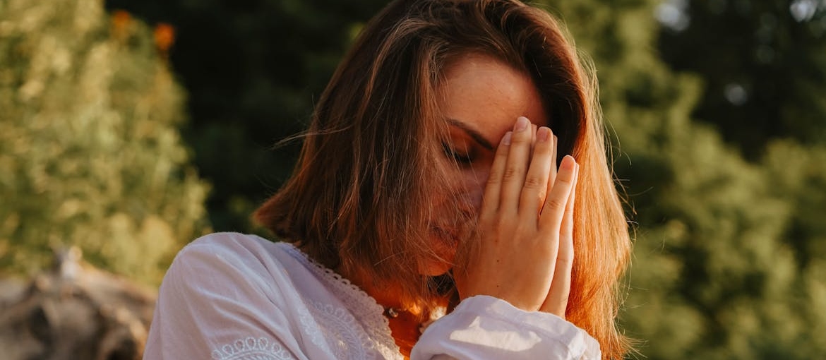 Woman covering her eyes while doing grounding exercises for marijuana anxiety.