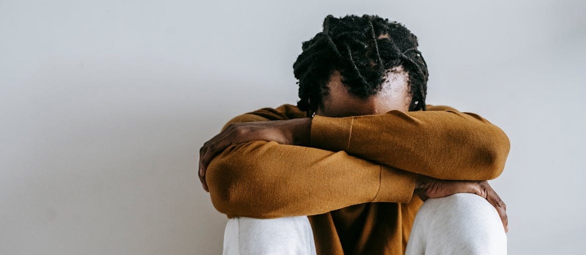 Man sitting with his head in his hands.