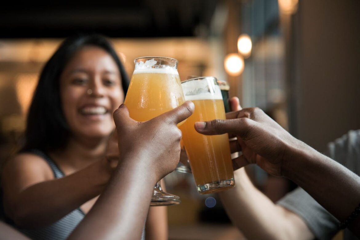 People toasting with glasses of beer.