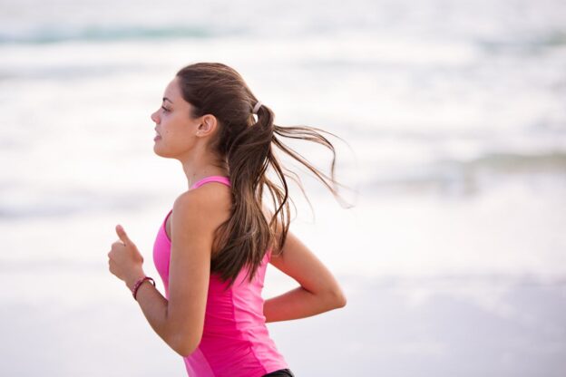 Woman jogging on the beach to support her healthy mind and body.