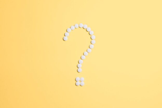 Question mark made with white pills.