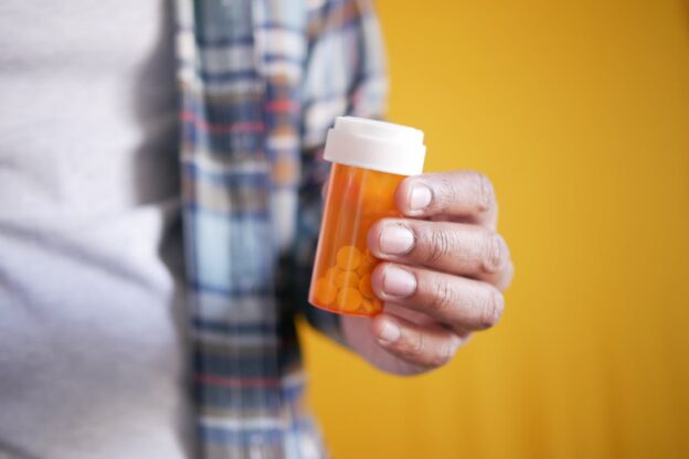 Man holding a prescription pills bottle.