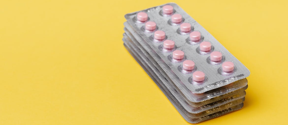 Blisters of pink pills stacked on top of each other.