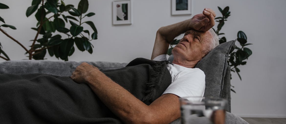 Older man lying on the couch and worrying about benzodiazepines and elderly.