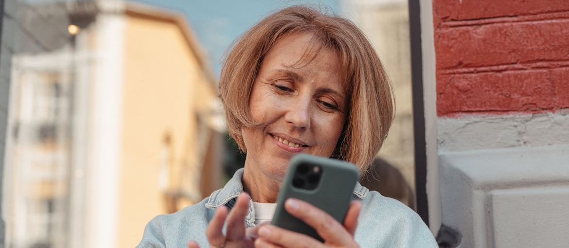 Woman smiling while looking at her phone.