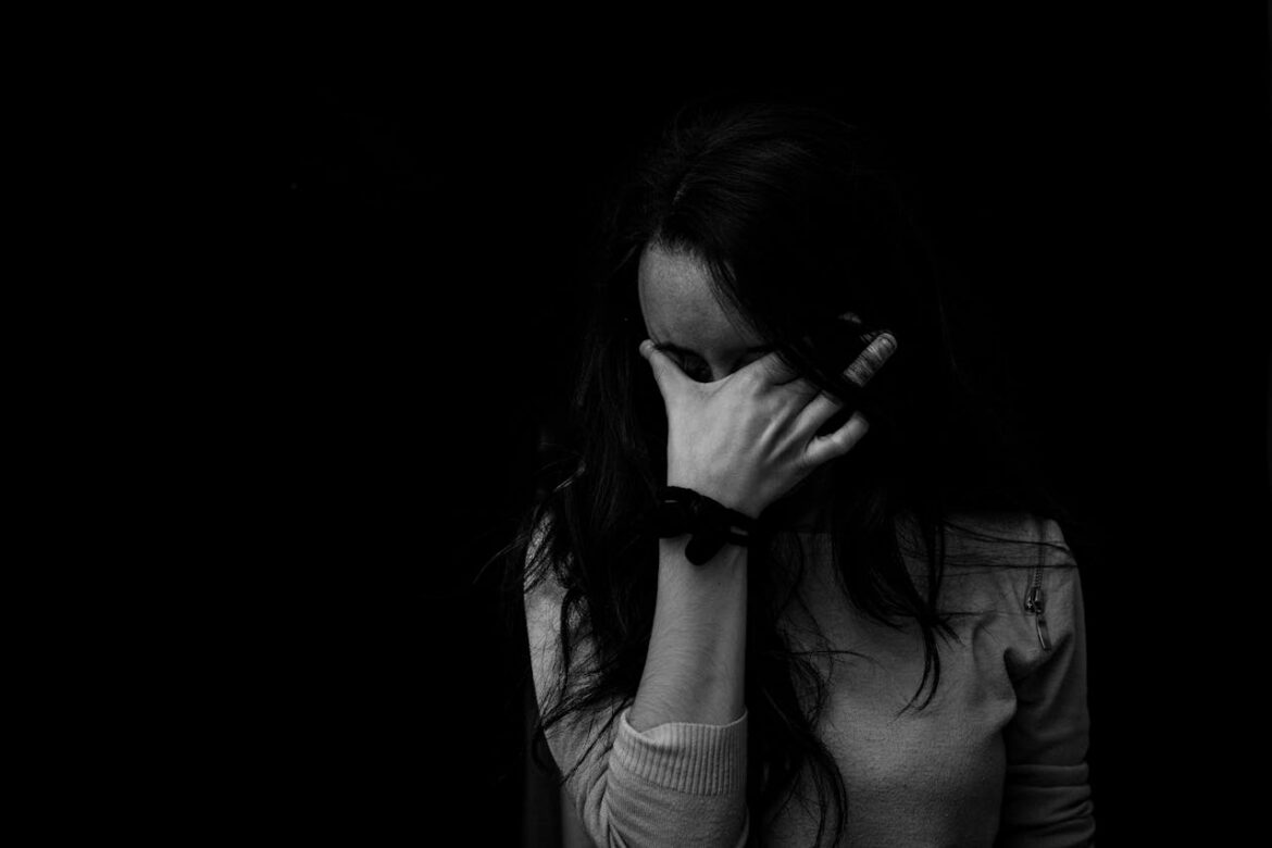 Woman covering her face with her hand.