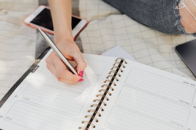 Woman writing her sober emergency plan in a notebook.