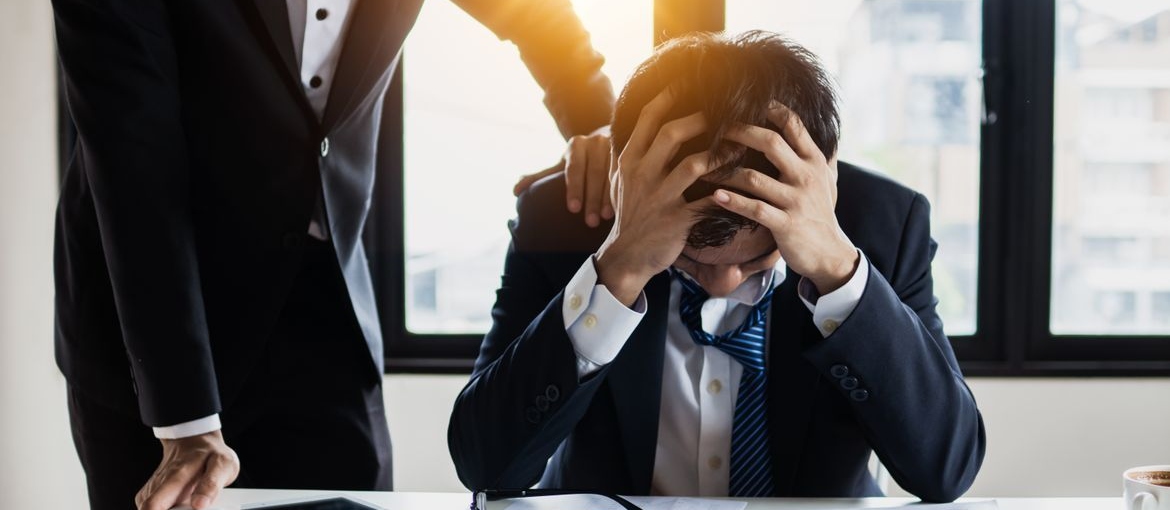 Man comforting an upset office worker.