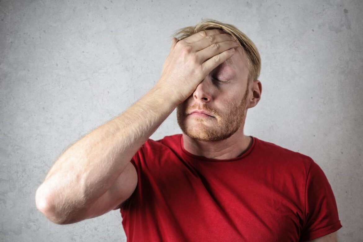 Man rubbing his head while trying to remember something.