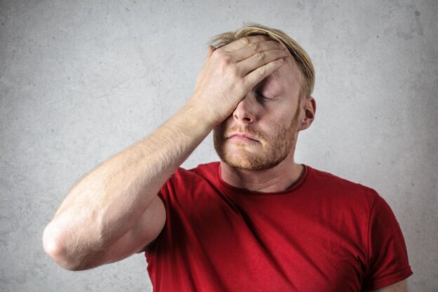 Man rubbing his head while trying to remember something.