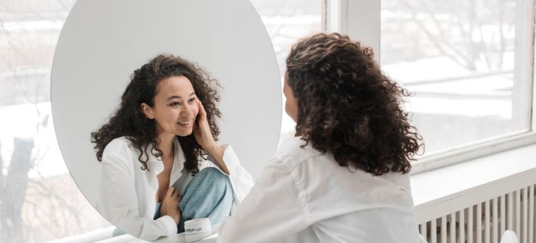 Woman smiling while looking at herself in the mirror.
