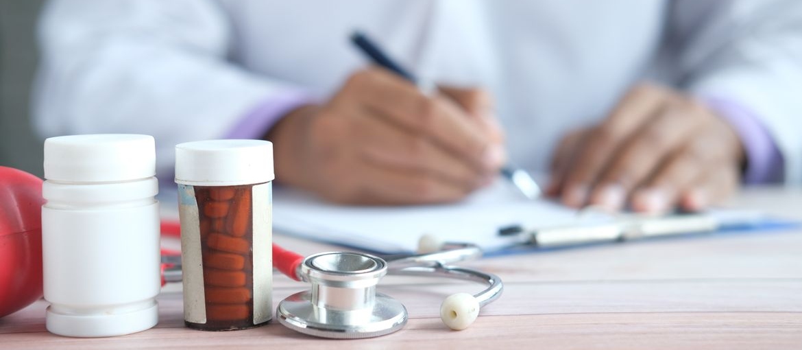 Doctor writing a prescription in a clipboard.